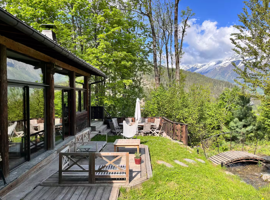 Terrasse en bois du chalet avec transats, face aux sommets enneigés
