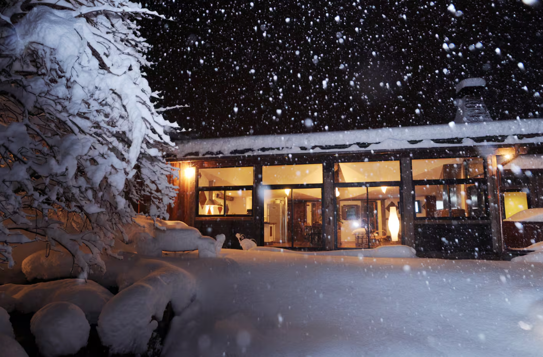 Le chalet sous la neige, éclairé, la nuit